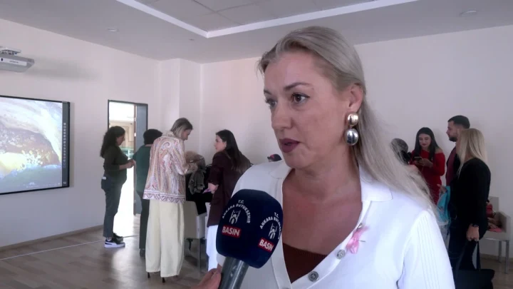 Meme kanseri farkındalık eğitimi sırasında bir kadın konuşurken görüntüleniyor.