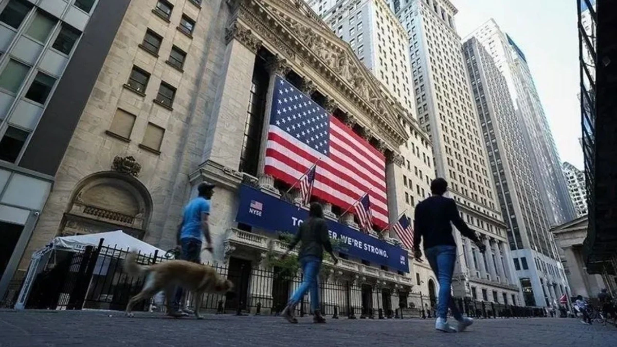 New York’ta ABD bayrağının bulunduğu borsa binası önünden geçen yayalar