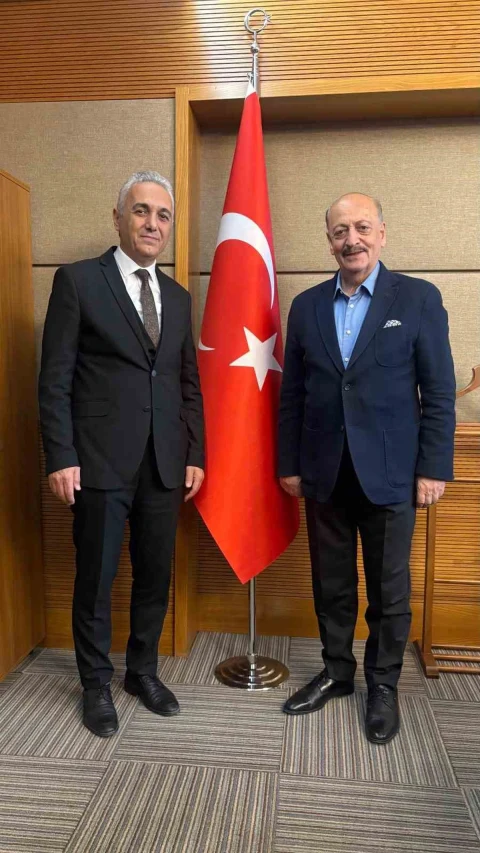 Adil Kurban ve Vedat Bilgin, Türk bayrağının önünde yan yana duruyor