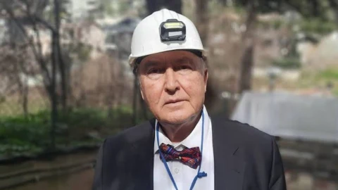 Prof. Dr. Övgün Ahmet Ercan beyaz baretle kameraya bakıyor