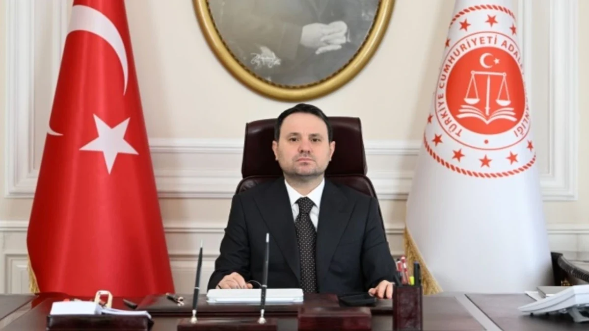 Adalet Bakanı Akın Gürlek, Türk bayrağı ve Adalet Bakanlığı bayrağı önünde makamında oturuyor.