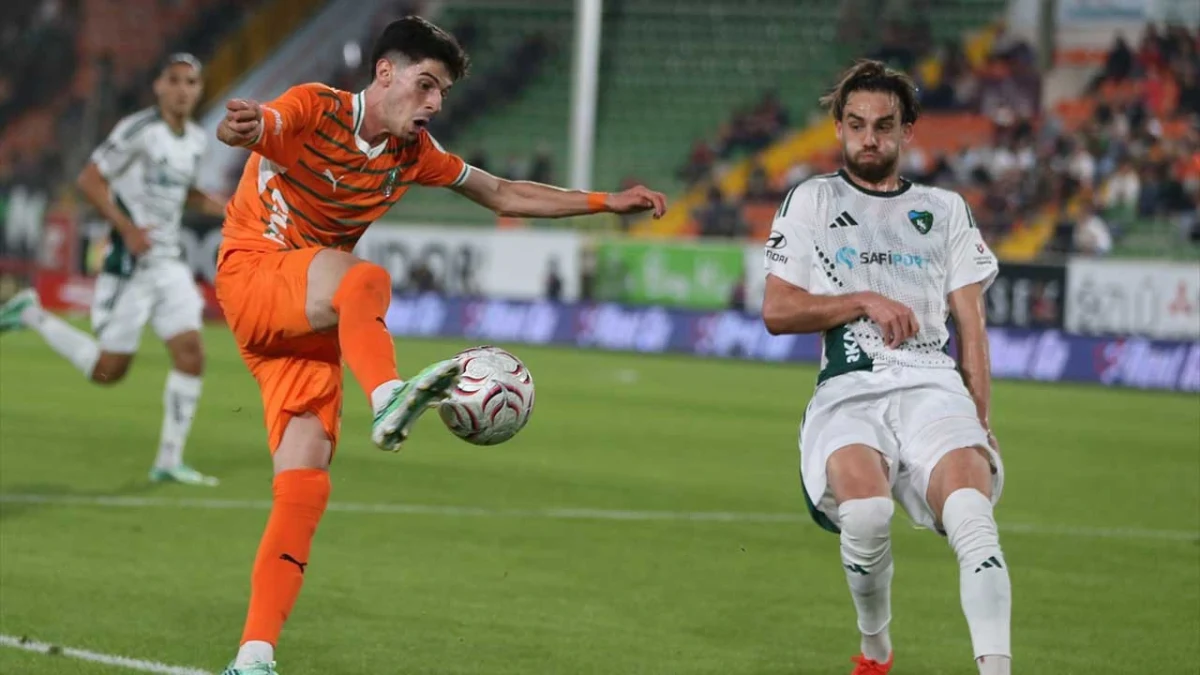 Alanyaspor ile Kocaelispor arasında oynanan maçta turuncu formalı oyuncu topa vururken beyaz formalı rakibi savunmada