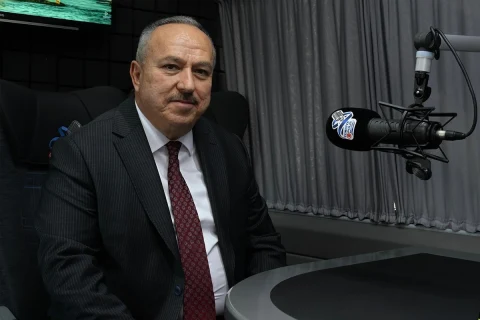 Emniyet Genel Müdürü Ali Fidan, Türkiye Polis Radyosu stüdyosunda mikrofonun yanında oturuyor.