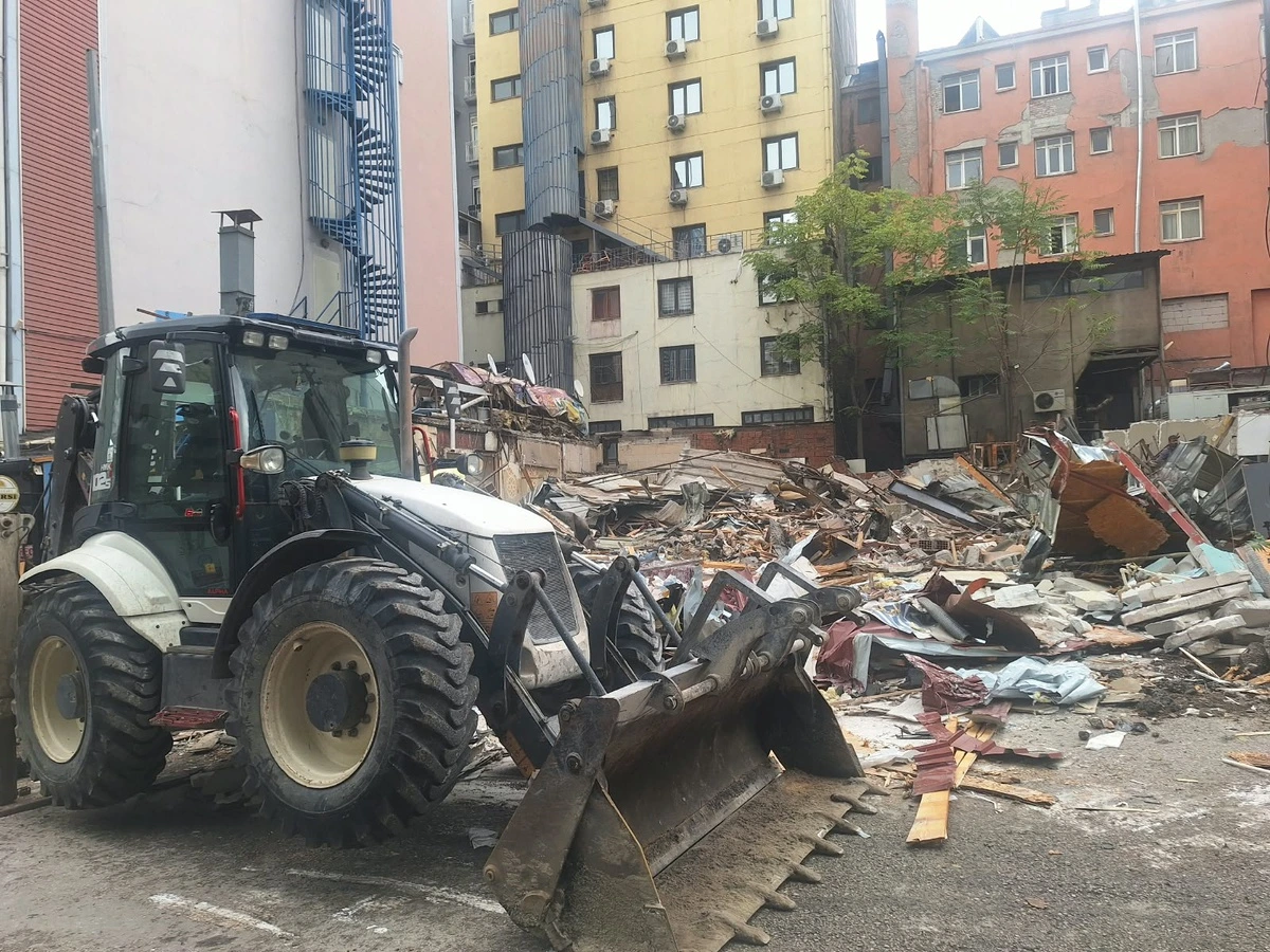 Altındağ’da yıkılan yapıların enkazı önünde çalışan iş makinesi