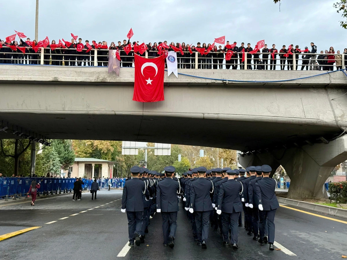 Cumhuriyet Bayramı geçit töreninde yürüyen üniformalı katılımcılar ve köprüde Türk bayrağı açan kalabalık