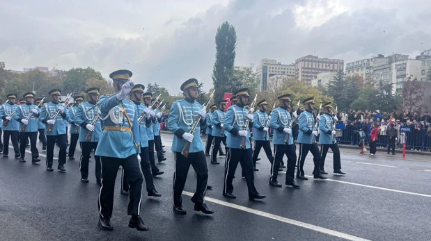 Mavi üniformalı kortej, geçit töreninde yürüyor