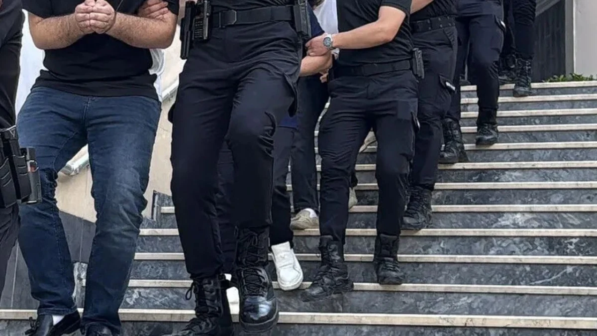 Polis ekipleri, gözaltına alınan bir kişiyi merdivenlerden indiriyor