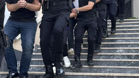 Polis ekipleri, gözaltına alınan bir kişiyi merdivenlerden indiriyor