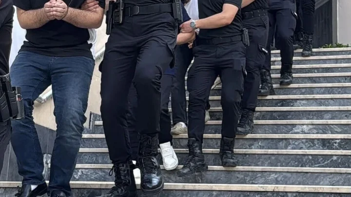 Polis ekipleri, gözaltına alınan bir kişiyi merdivenlerden indiriyor