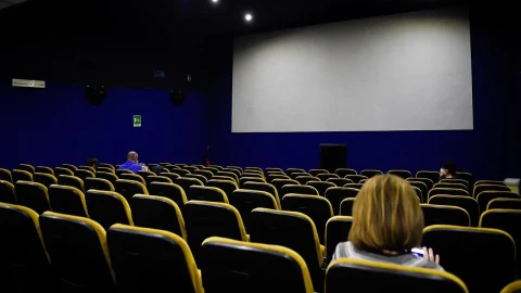 Bir sinema salonunda film gösterimi için boş koltuklar ve perde