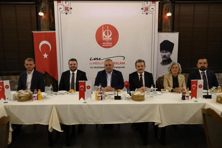 Keçiören’de Muhtarlar Günü programında belediye başkanı ve konuklar masada oturuyor