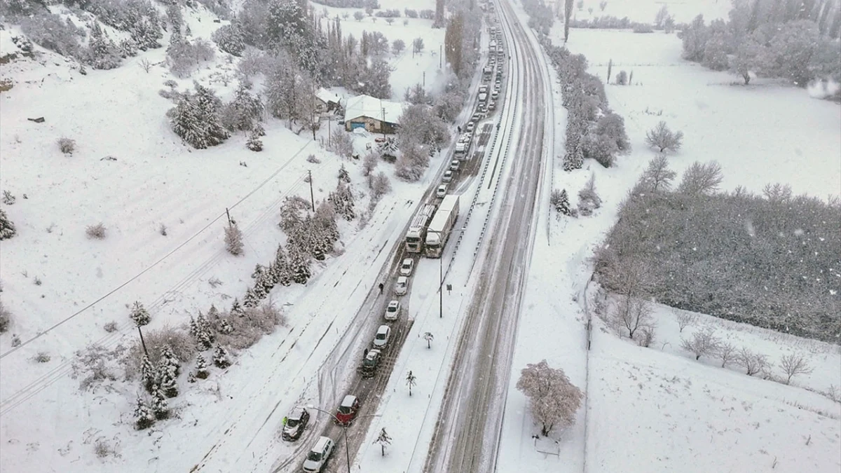 Kar yağışı altında uzanan yol ve çevresindeki beyaz örtüyle kaplı alanlar