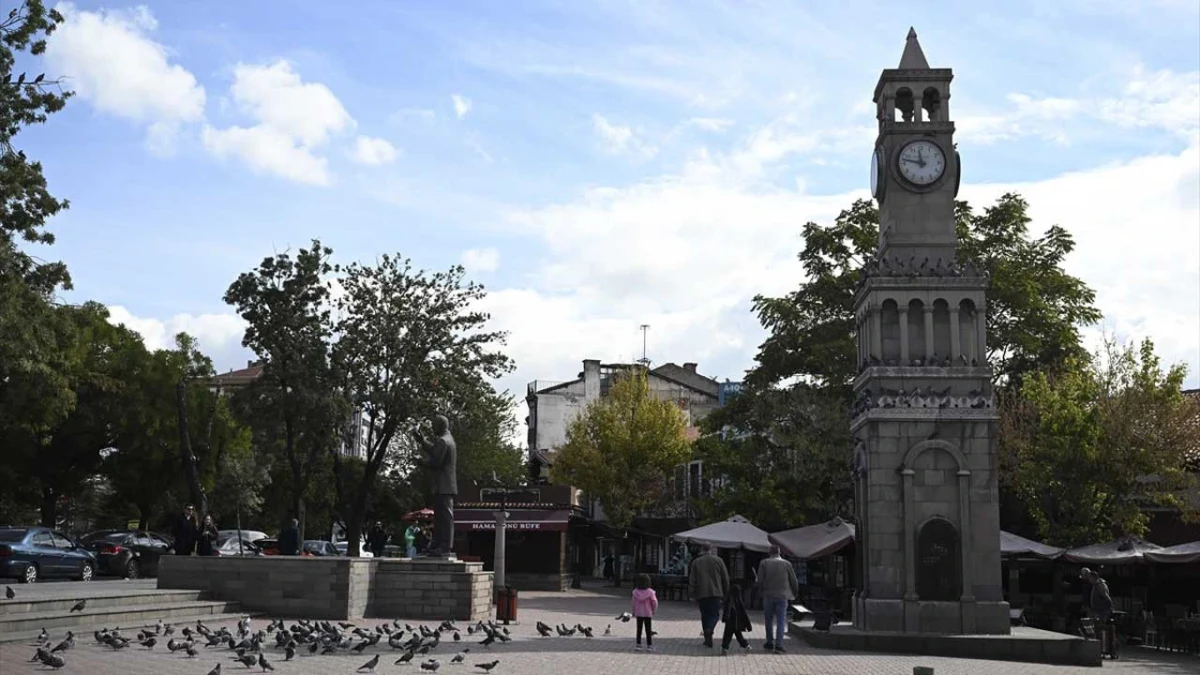 Ankara’da meydandaki saat kulesi çevresinde yürüyen insanlar ve güvercinler