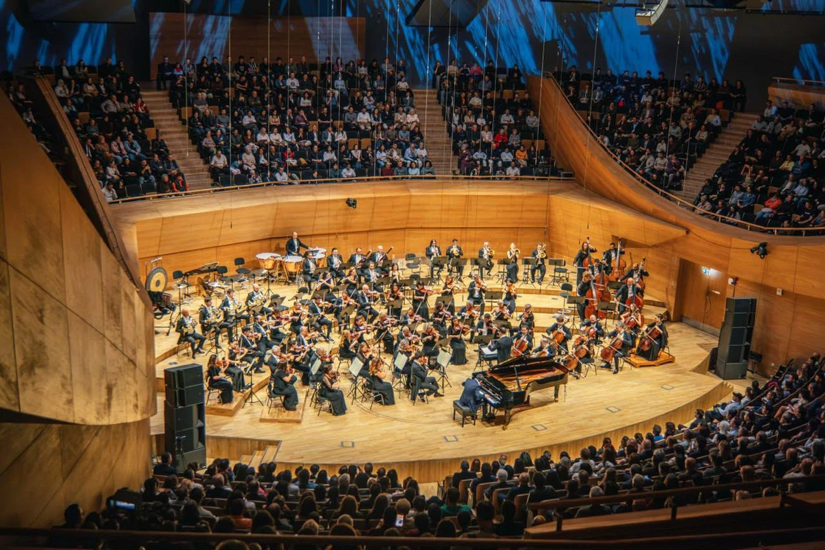 Seyircilerle dolu bir salonda sahne alan orkestra
