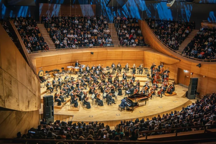 Seyircilerle dolu bir salonda sahne alan orkestra