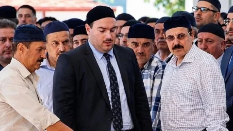 Kalabalık bir grup arasında siyah takım elbiseli bir erkek