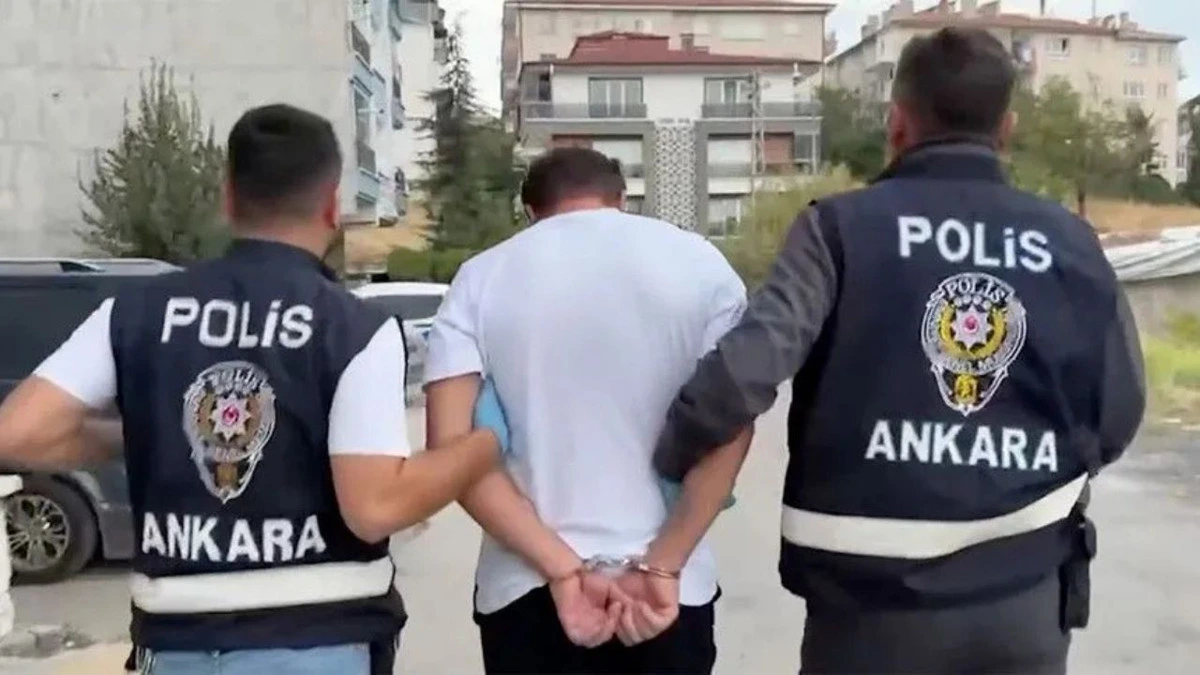 Ankara polisi gözaltındaki şüpheliyi ekip aracına götürüyor