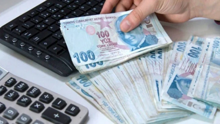 Hesap makinesi yanında Türk lirası banknotlarını sayan el