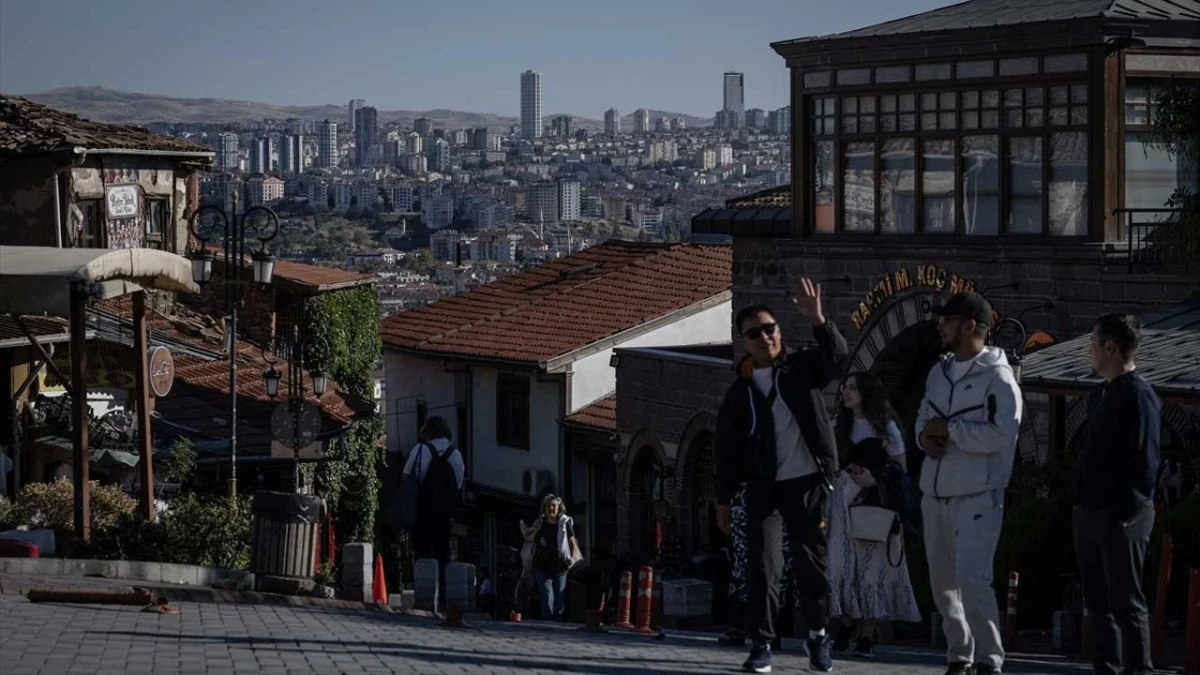 Ankara’da tarihi yapıların önünde yürüyen insanlar ve arka planda kent manzarası