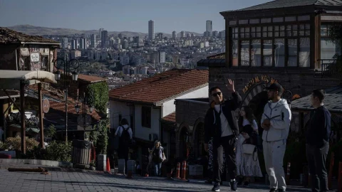 Ankara’da tarihi yapıların önünde yürüyen insanlar ve arka planda kent manzarası