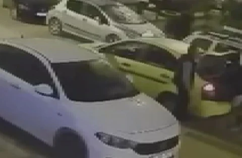 Sokakta park halinde duran otomobiller ve sarı taksi