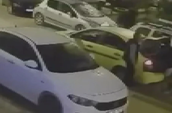 Sokakta park halinde duran otomobiller ve sarı taksi
