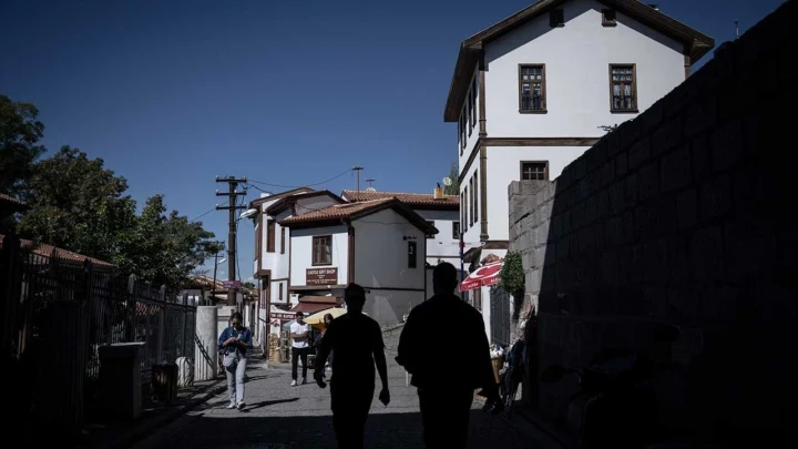 Ankara’da geleneksel mimarili yapıların bulunduğu dar bir sokakta yürüyen yayalar