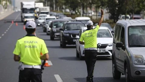 Trafik polisi, araçların bulunduğu yolda trafiği yönlendiriyor.