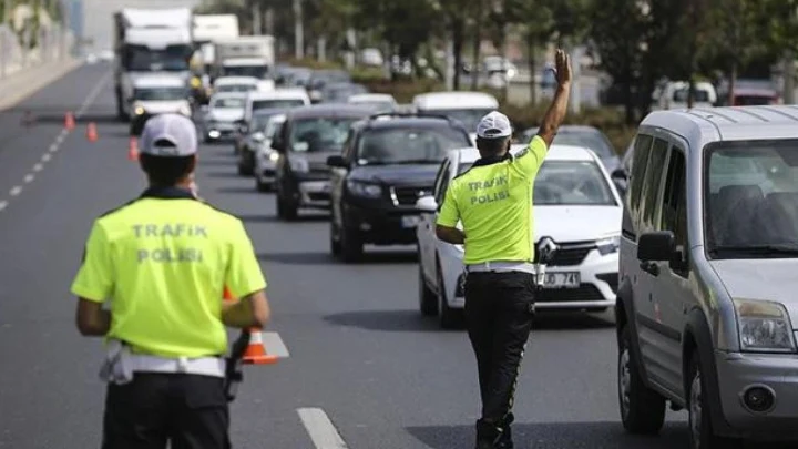 Trafik polisi, araçların bulunduğu yolda trafiği yönlendiriyor.