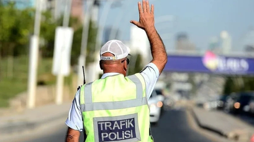 Trafik polisi, araç trafiğini durdurmak için elini kaldırıyor