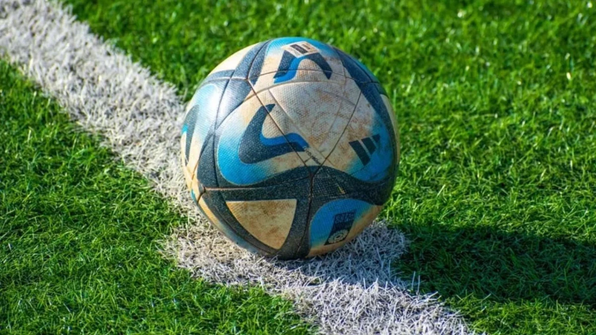 Çim sahadaki beyaz çizginin üzerinde duran futbol topu