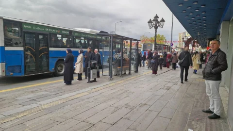 Ankara Ulus’ta cam panelli ve üzeri kapalı otobüs durağında bekleyen yolcular