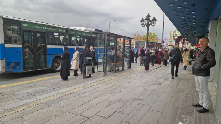 Ankara Ulus’ta cam panelli ve üzeri kapalı otobüs durağında bekleyen yolcular