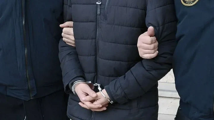 Jandarma eşliğinde kelepçeli bir şüpheli