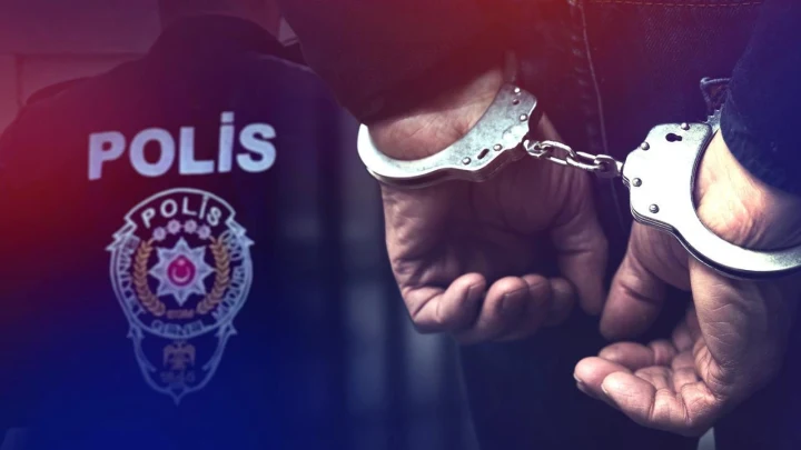 Polis yeleği önünde kelepçeli eller