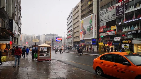 Yağışlı havada şehir merkezinde araçlar ve yayalar