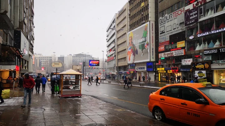 Yağışlı havada şehir merkezinde araçlar ve yayalar