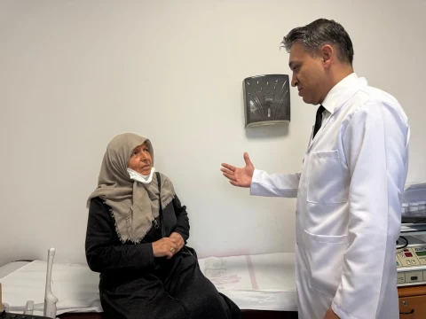 Muayene odasında oturan hasta ile konuşan doktor