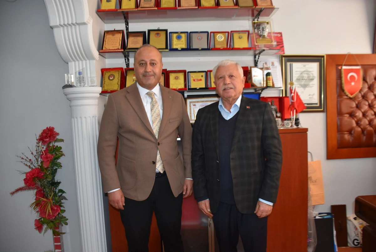 Atakan Çelik, yerel basın temsilcisiyle ödül ve plaketlerin bulunduğu odada