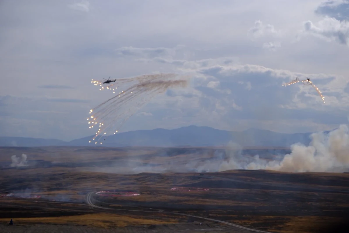Tatbikat sahasında karşı tedbir fişekleri kullanan helikopter