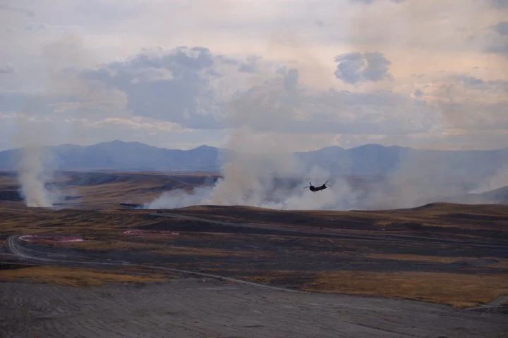 Polatlı’daki Ateş Serbest-2026 faaliyetinde atış alanında yükselen dumanların önünde uçan helikopter