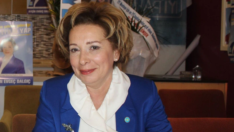 Ayçin Evgeç Dalgıç mavi ceket ve beyaz bluzla otururken
