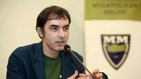 Gazeteci Bahadır Özgür bir etkinlikte mikrofon başında konuşurken