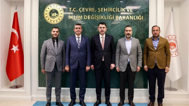 Mesut Özarslan ve Levent Koç’un da aralarında bulunduğu beş kişi, Çevre, Şehircilik ve İklim Değişikliği Bakanlığı tabelasının önünde yan yana duruyor.