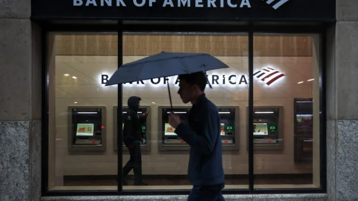 Bank of America şubesinin önünden şemsiyeyle geçen kişi