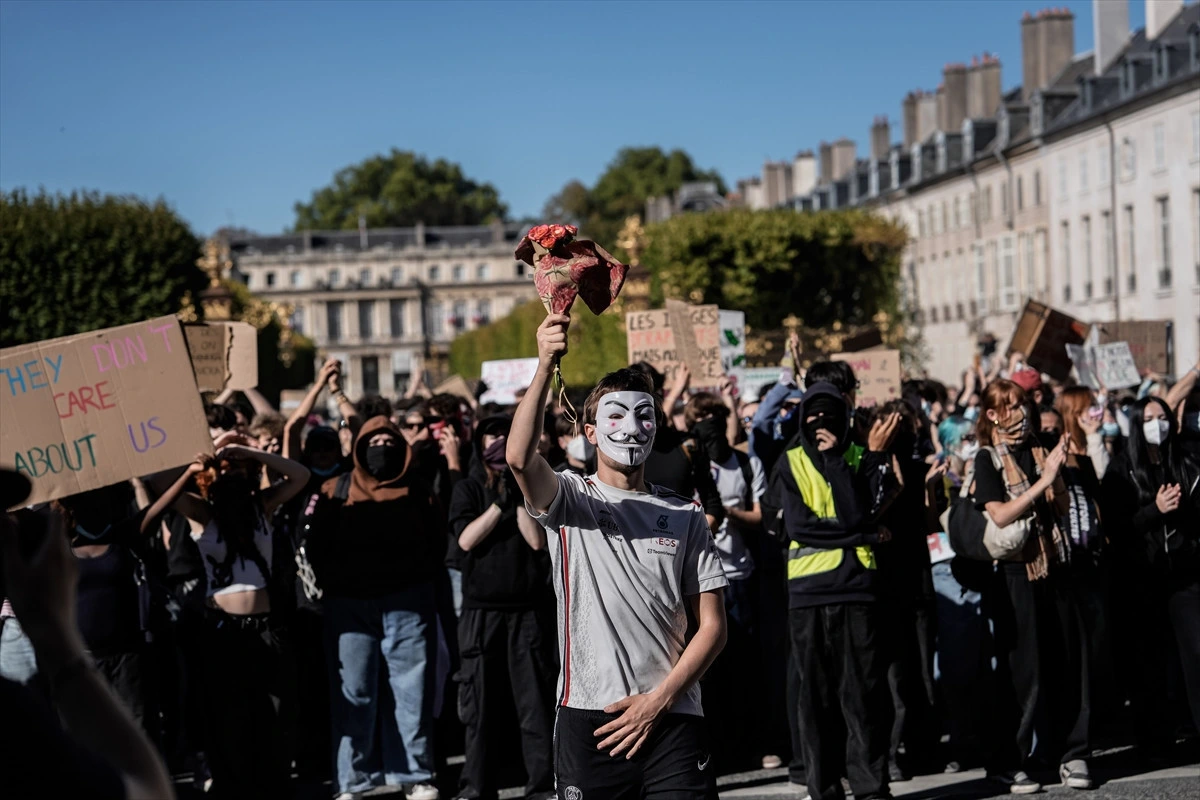 Bastille’de çiçek taşıyan maskeli protestocu ve göstericiler