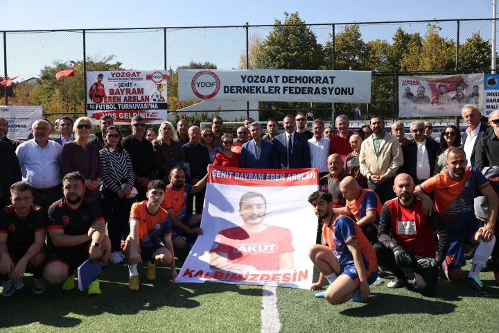 Bayram Eren Arslan anısına düzenlenen futbol turnuvasına katılanlar, şehidin fotoğrafının yer aldığı pankartla poz veriyor.
