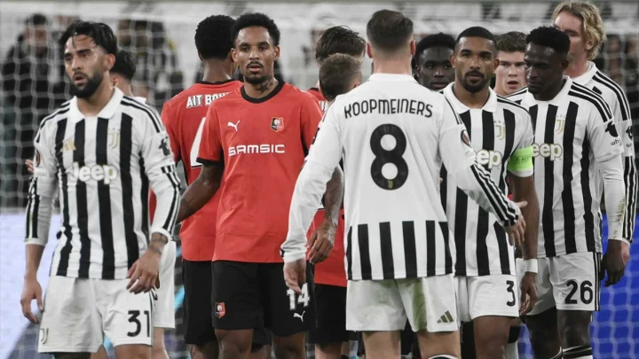 Siyah-beyaz formalar giyen futbolcuların maç öncesinde sahada bir arada durduğu an