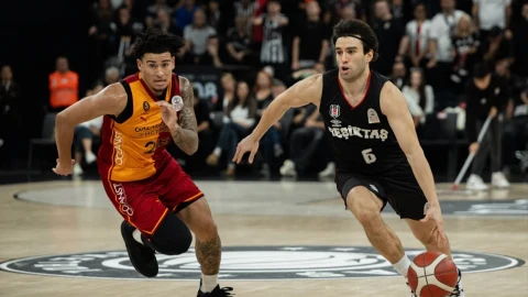 Beşiktaşlı oyuncu top sürerken Galatasaraylı oyuncu savunma yapıyor