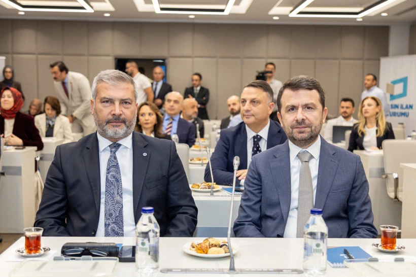 Çalıştayın ön sırasındaki iki katılımcı toplantı masasında oturuyor